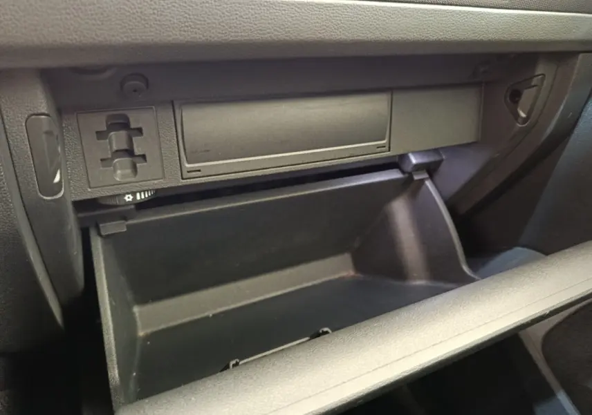 Gros plan sur la boîte à gants ouverte de la Volkswagen Tiguan 2.0 TDI 150 DSG7 Elegance noire, intérieur noir.