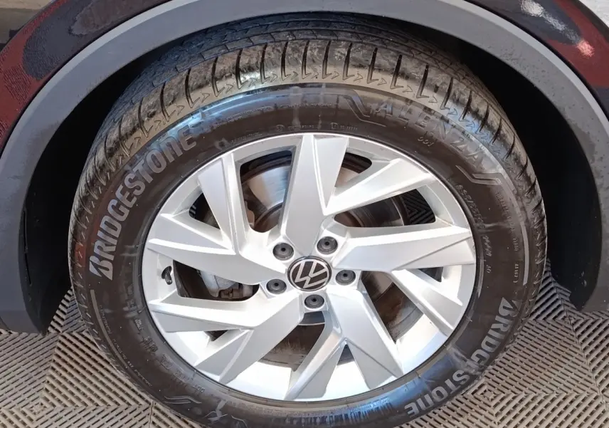 Gros plan sur la roue avant droite d’un Volkswagen Tiguan noir, jante alliage argentée et pneu Bridgestone visible.