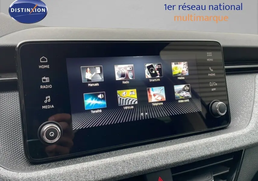 Écran tactile central du Skoda Kamiq blanc glacier, affichant le menu principal avec icônes colorées, vue intérieure rapprochée.