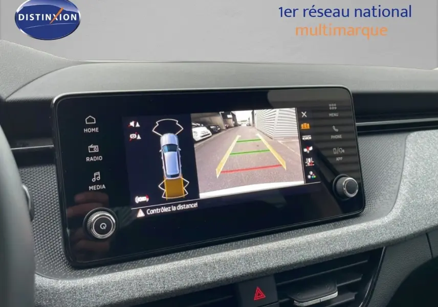 Écran central du Skoda Kamiq blanc glacier 2025 montrant la caméra de recul avec guidage de trajectoire.
