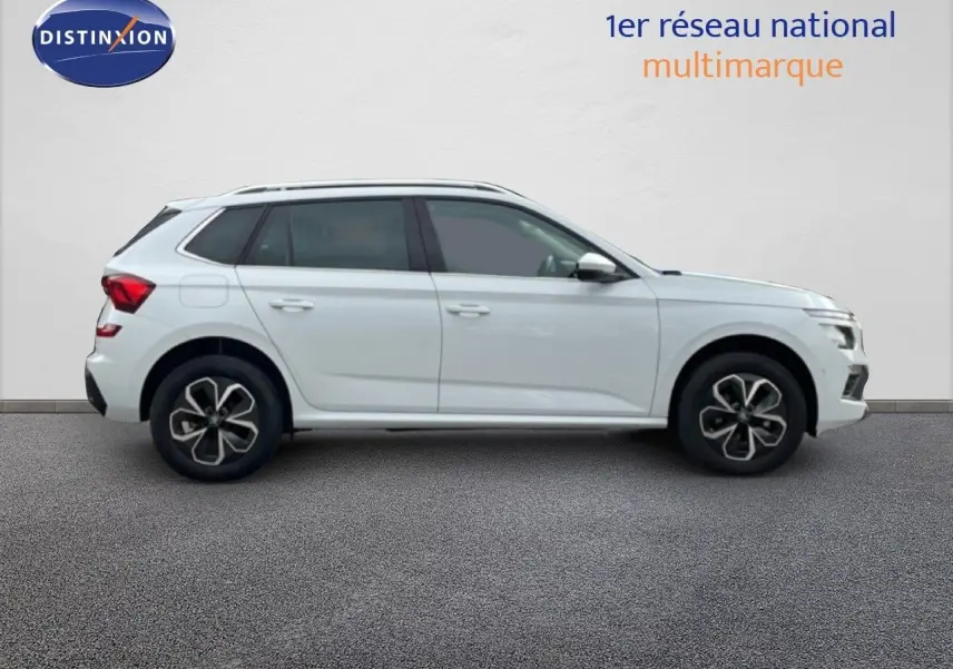 Profil droit d'un Skoda Kamiq blanc glacier 2025 avec jantes alliage et vitres teintées, sur fond neutre intérieur.