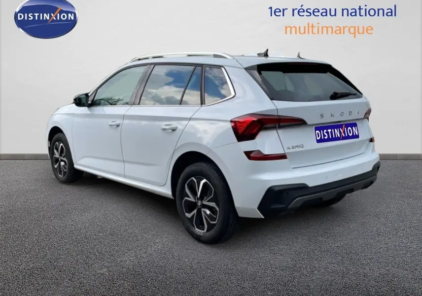 Vue 3/4 arrière droite d’un Skoda Kamiq blanc glacier 2025 avec jantes noires et toit ouvrant.