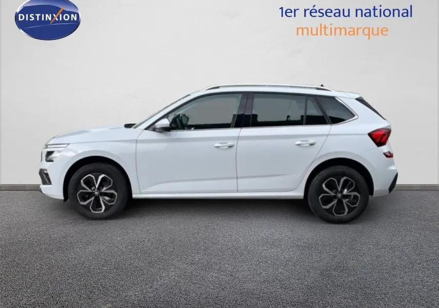 Vue de profil côté gauche d'un Skoda Kamiq blanc glacier 2025 avec jantes noires et toit panoramique.