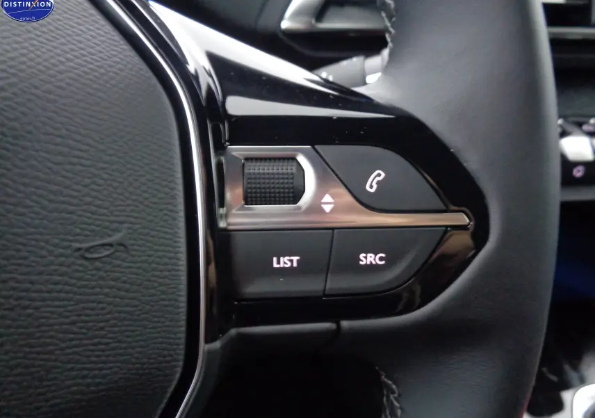 Gros plan sur les commandes gauche du volant noir du Peugeot 3008 gris platinium, avec boutons LIST et SRC éclairés.