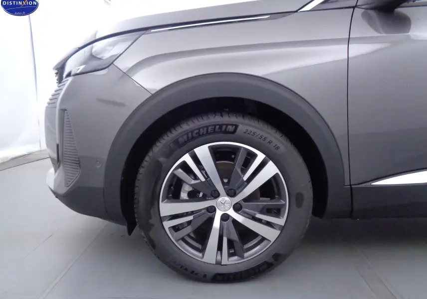 Gros plan sur la roue avant gauche du Peugeot 3008 gris platinium métal, mettant en valeur la jante alliage et le pneu Michelin.