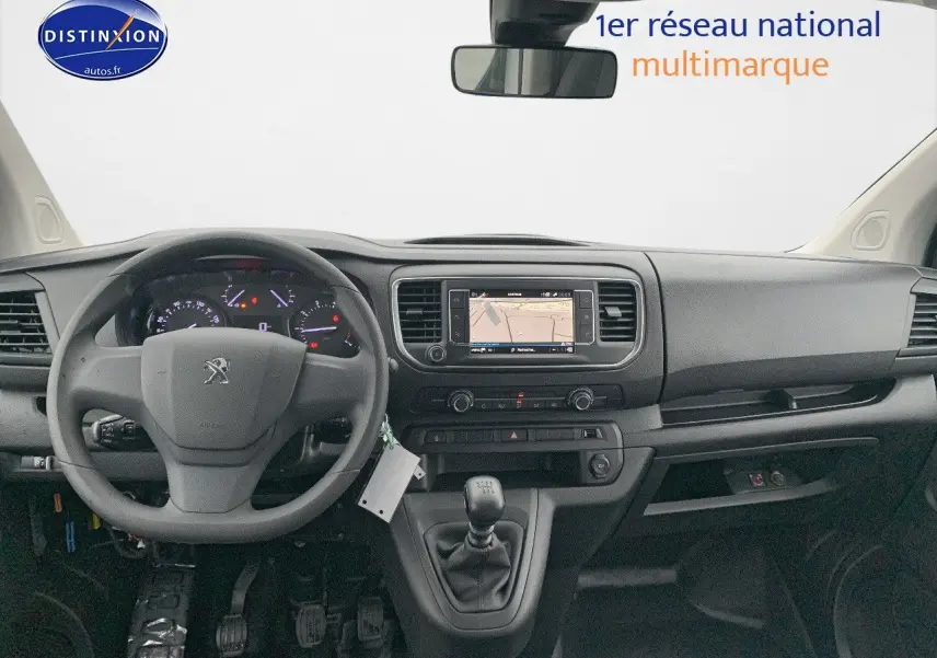 Vue intérieure frontale du Peugeot Expert Long 2023 avec tableau de bord noir, volant, écran GPS et levier de vitesses manuel.