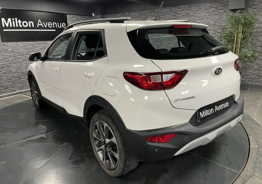 Vue 3/4 arrière droite du KIA Stonic blanc avec jantes alliage et détails noirs sur boucliers et passages de roues.