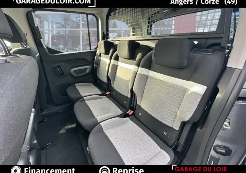 Vue intérieure côté droit sur la banquette arrière grise et noire du Citroën Berlingo 2024 avec grille de séparation.