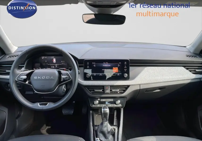 Vue intérieure frontale du tableau de bord du Skoda Kamiq gris argent, avec écran tactile central et volant multifonction.