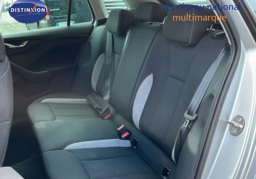 Vue intérieure côté arrière droit du Skoda Kamiq 2025 gris argent, montrant les sièges arrière en tissu noir et gris.