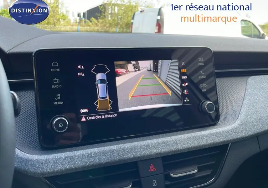 Écran central de la Skoda Kamiq gris argent 2025 montrant la caméra de recul avec guidage de trajectoire.