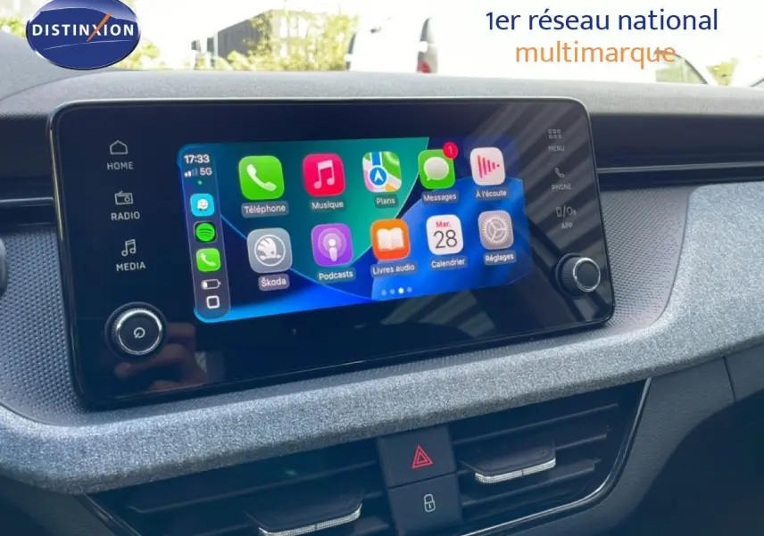 Écran tactile central du Skoda Kamiq 2025 affichant les applications, avec tableau de bord gris argent métallique en arrière-plan.