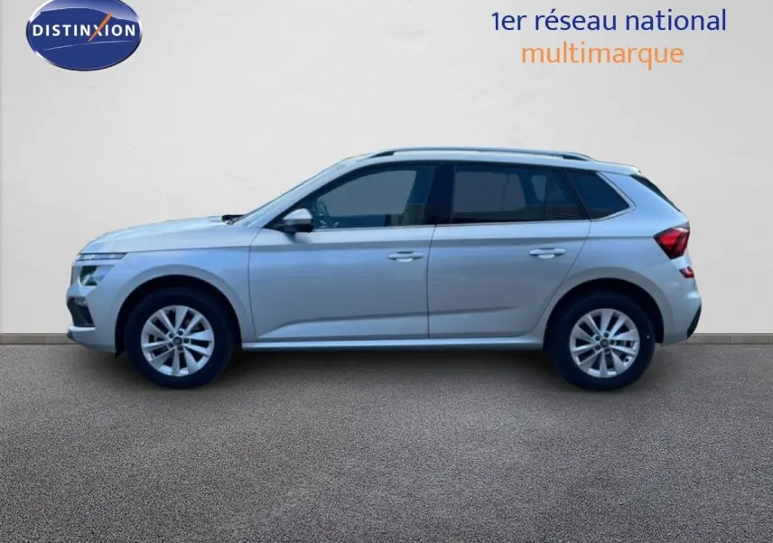 Vue de profil côté gauche d'un Skoda Kamiq gris argent métallisé, SUV compact avec jantes alliage et vitres teintées.