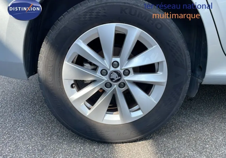 Gros plan sur la roue avant droite d’un Skoda Kamiq gris argent métal avec jante alliage à plusieurs branches.