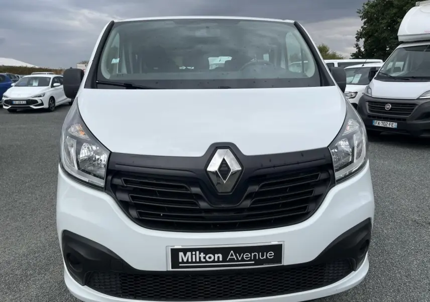 Vue frontale d'un Renault Trafic Fourgon blanc avec calandre noire et logo Renault bien visible.