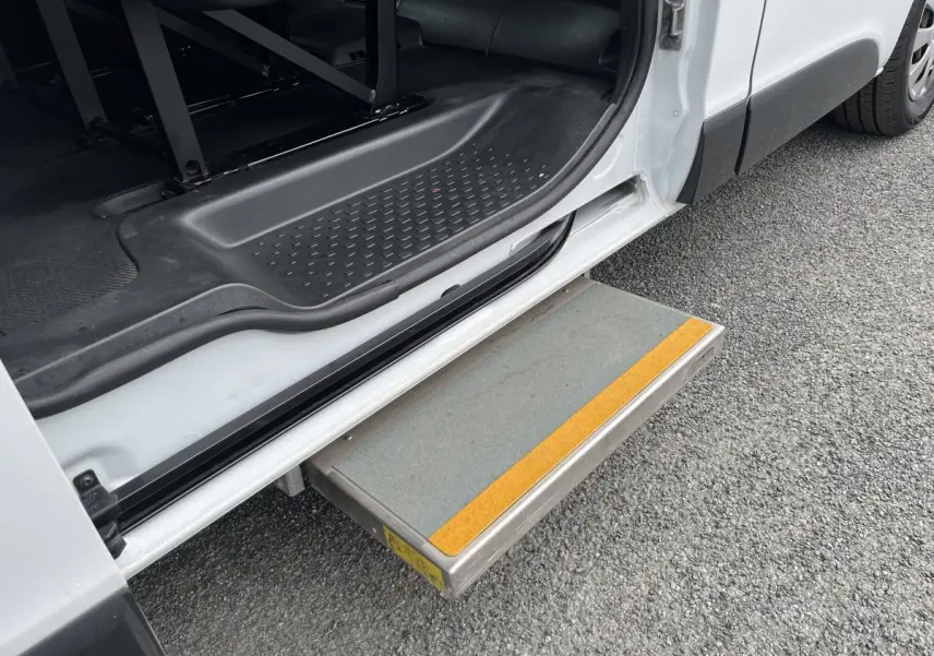 Marche-pied déployé côté gauche du Renault Trafic blanc, avec seuil d'entrée et intérieur noir visible.