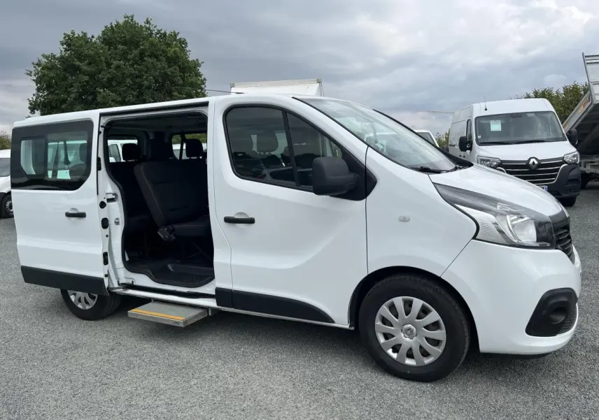 Renault Trafic Fourgon blanc vu de profil droit avec porte latérale coulissante gauche ouverte et marchepied déployé.