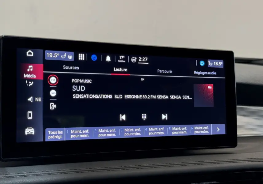 Écran tactile central de l'Alfa Romeo Tonale rouge 2023 affichant la radio FM et les réglages audio.
