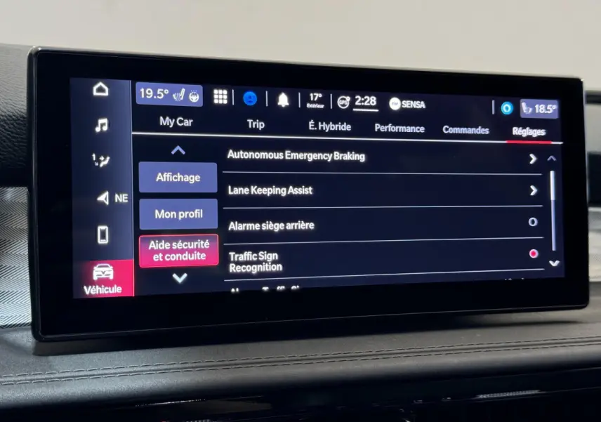Écran tactile central affichant les réglages d'aide à la conduite de l'Alfa Romeo Tonale hybride rouge, vue intérieure frontale.