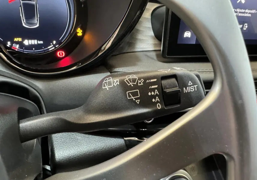 Gros plan sur la manette d’essuie-glace noire et le tableau de bord numérique de l’Alfa Romeo Tonale rouge 2023.