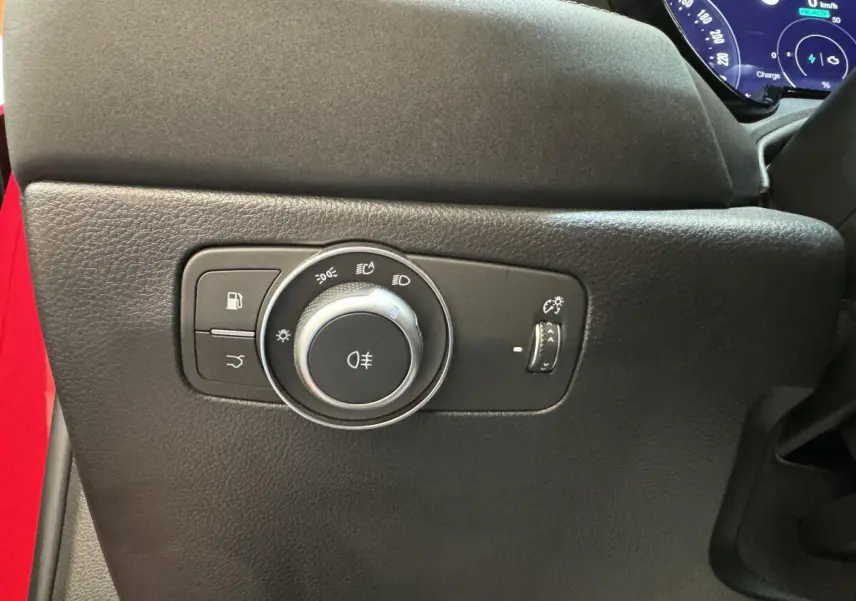 Gros plan sur la commande des feux et éclairage intérieur côté gauche d'un Alfa Romeo Tonale rouge 2023.