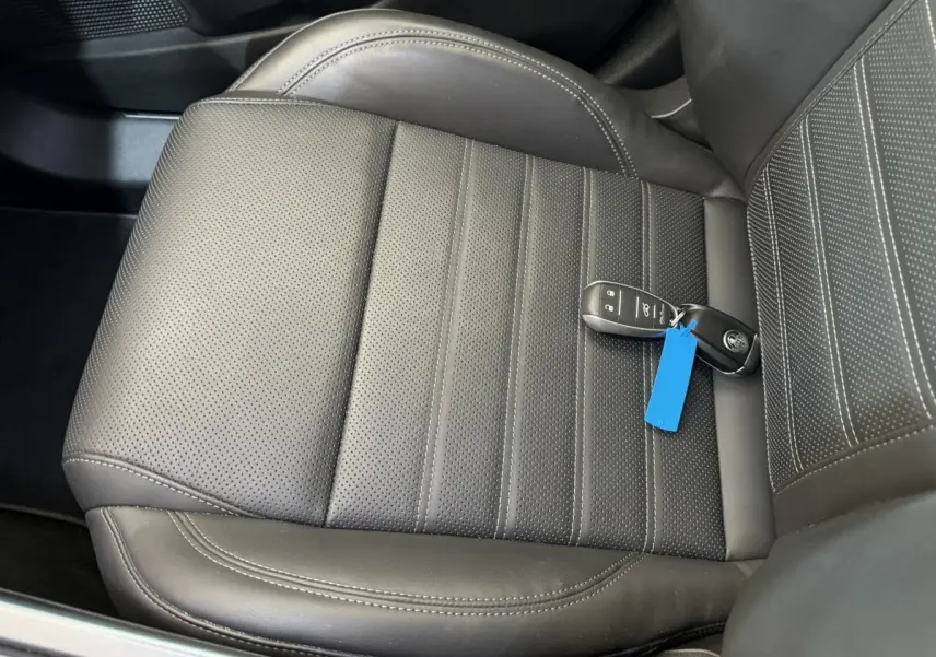 Gros plan sur le siège avant en cuir noir perforé avec la clé de l'Alfa Romeo Tonale posée dessus.