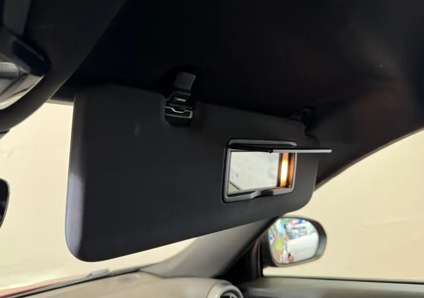 Détail du pare-soleil côté conducteur avec miroir éclairé dans l'habitacle rouge de l'Alfa Romeo Tonale 2023