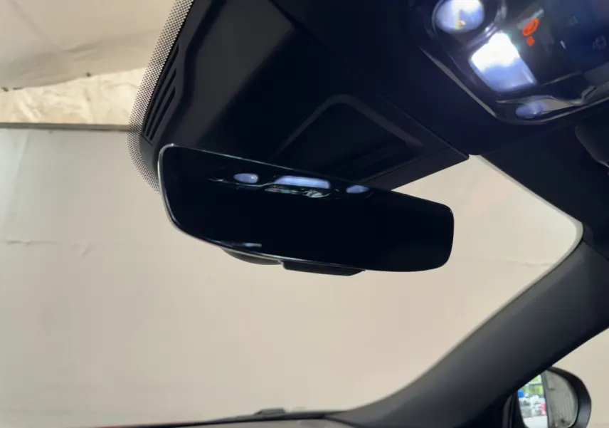 Vue intérieure rapprochée du rétroviseur central noir brillant de l'Alfa Romeo Tonale 2023, avec partie du pare-brise visible.