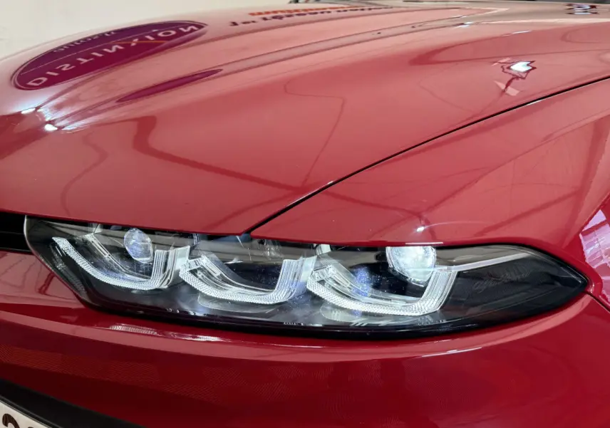 Gros plan sur le phare avant droit LED d'une Alfa Romeo Tonale rouge 2023, soulignant ses lignes modernes et précises.