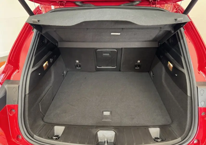 Coffre ouvert vu de l'arrière d'une Alfa Romeo Tonale rouge 2023, espace de chargement propre et éclairé.