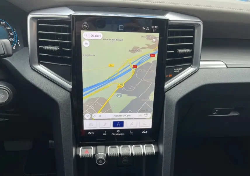 Vue rapprochée du tableau de bord noir du Volkswagen Amarok 2025 avec écran tactile central affichant la navigation.
