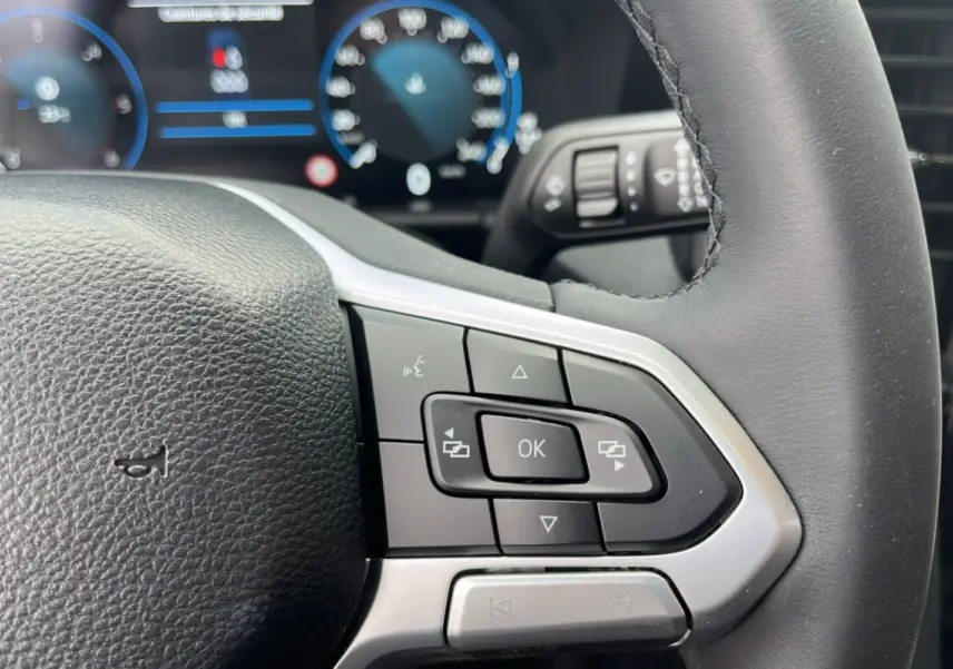 Gros plan sur les commandes multifonctions à droite du volant en cuir noir du Volkswagen Amarok Simple Cabine 2025.