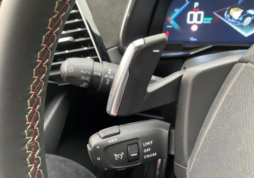 Gros plan sur les commandes au volant du DS7 Crossback E-Tense 300 gris platinium, affichage numérique en arrière-plan.