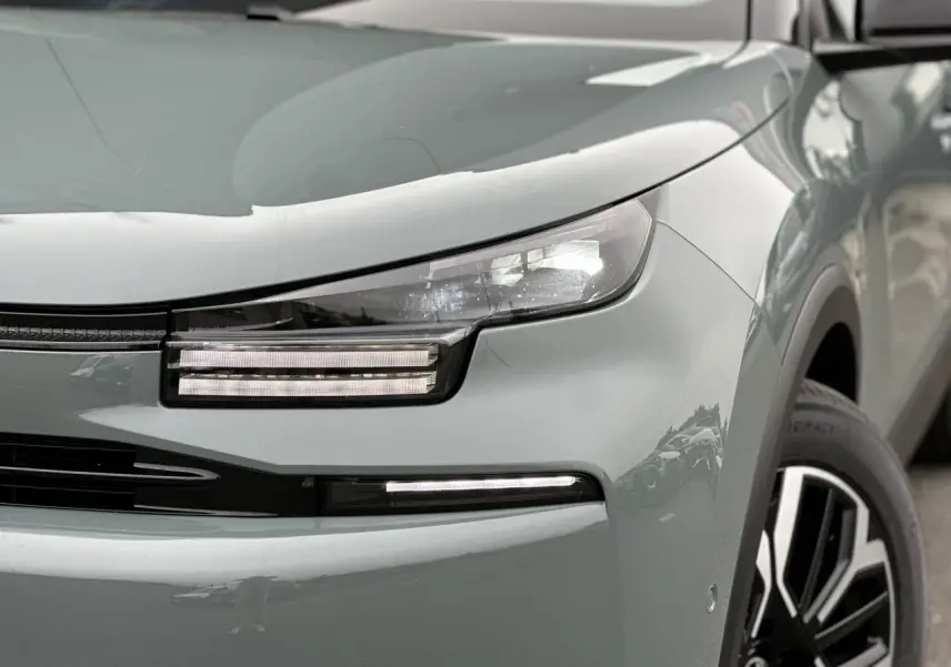 Gros plan sur l'avant droit de la Citroën C4 Manhattan Green avec ses phares LED et jante alliage noire et argent.