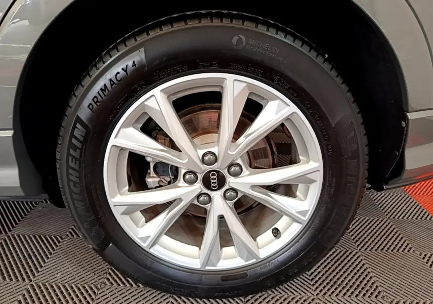 Gros plan sur la roue avant droite gris foncé d'un Audi Q3 35 TFSI S Line avec jante alliage et pneu Michelin.