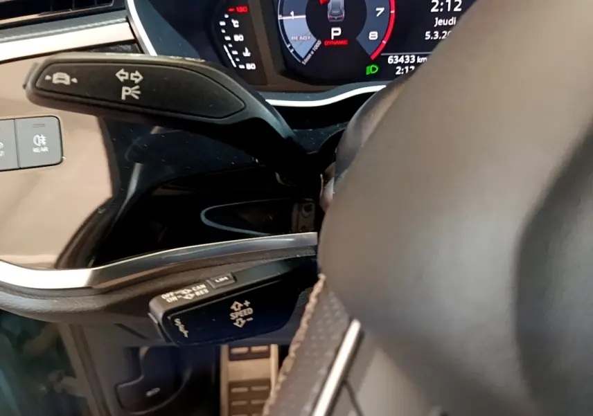 Gros plan sur le volant cuir et les commandes multifonctions du tableau de bord de l'Audi Q3 gris foncé 35 TFSI 2021.