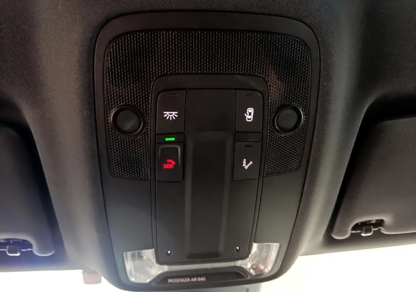 Vue en plongée du panneau de commandes au plafond de l'Audi Q3 gris foncé avec bouton SOS et éclairage intégré.
