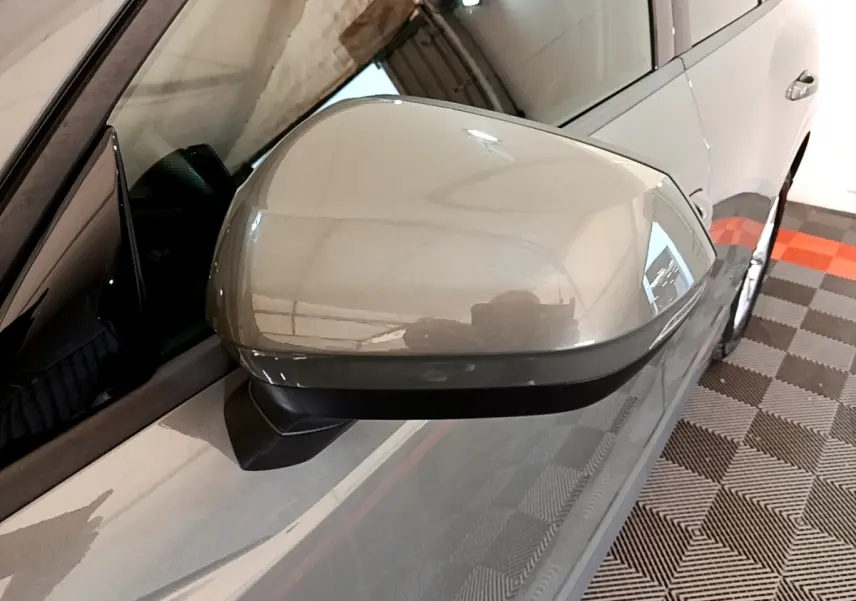 Rétroviseur côté conducteur gris foncé de l'Audi Q3 35 TFSI 150 MHEV S Line, vue rapprochée en intérieur.