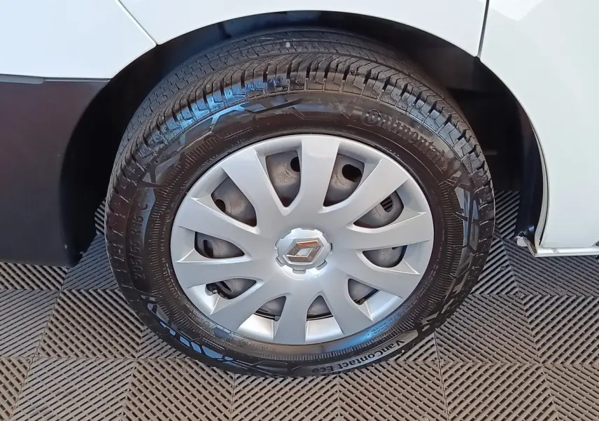 Gros plan sur la roue avant droite d’un Renault Trafic blanc, avec enjoliveur argenté et pneu Continental noir.