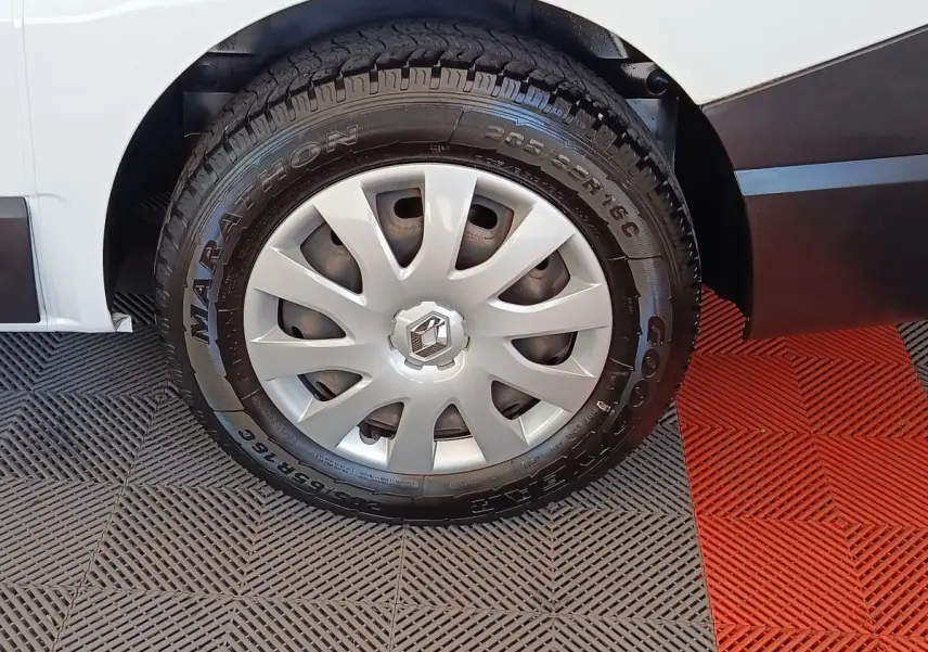 Gros plan sur la roue avant droite d’un Renault Trafic blanc, avec jante acier et enjoliveur gris.