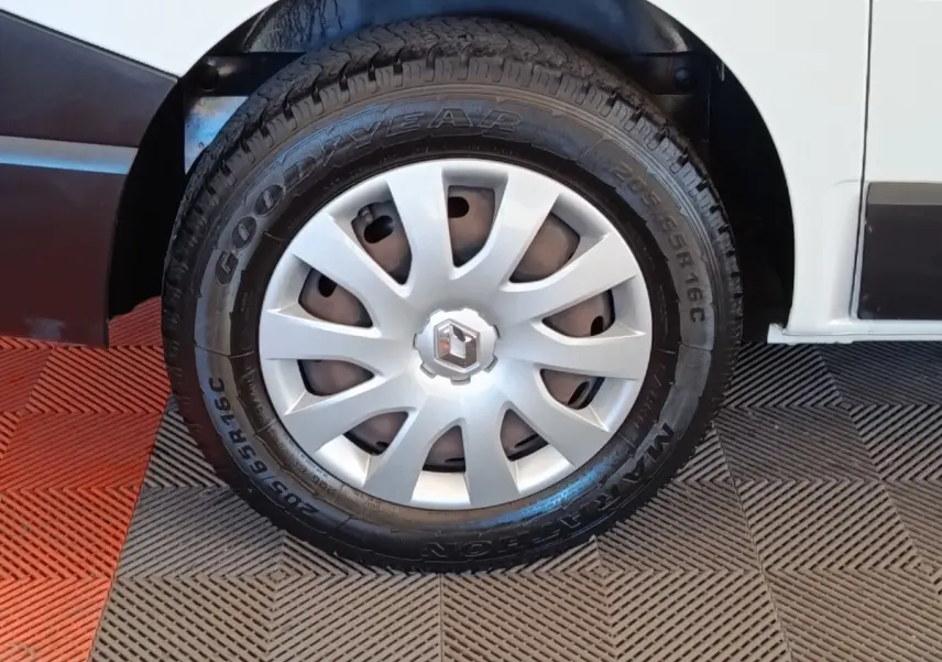 Gros plan sur la roue avant droite blanche d’un Renault Trafic Fourgon avec enjoliveur argenté et pneu Goodyear.