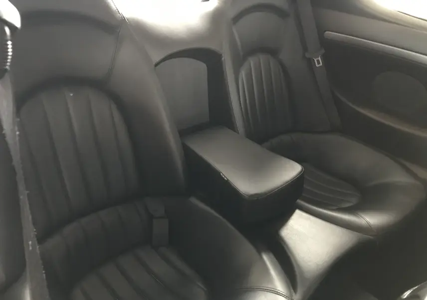 Vue rapprochée des sièges arrière en cuir noir du Maserati Coupé 4.2l V8 gris clair de 2003.