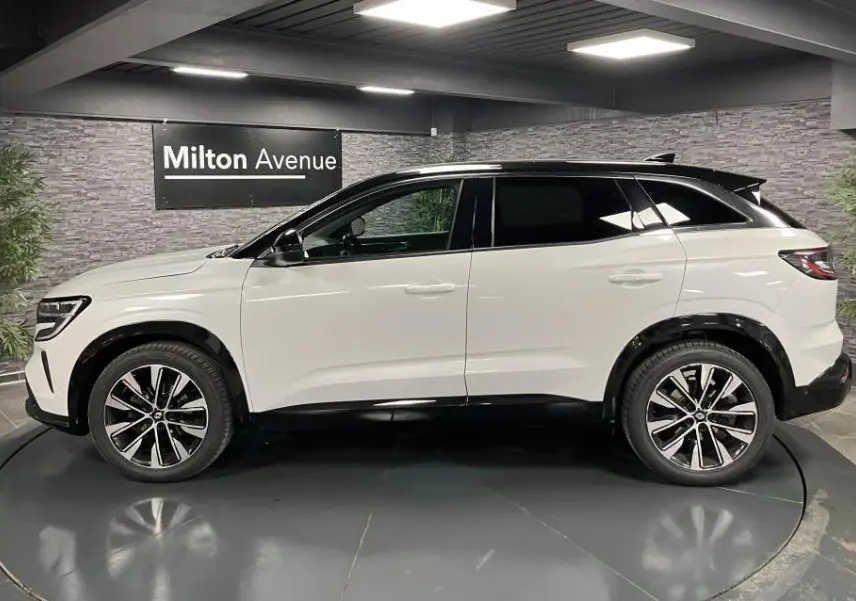 Profil droit du Renault Austral blanc Glacier avec toit noir étoilé et jantes alliage 19 pouces Komah diamantées noires.