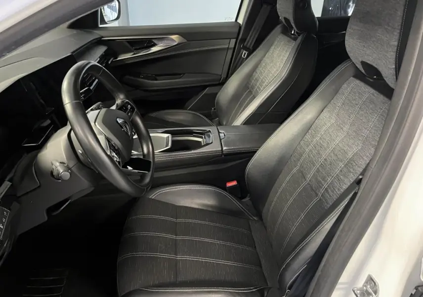 Intérieur avant droit du Renault Austral 2023, sièges mixte simili-cuir gris et volant cuir noir visible.