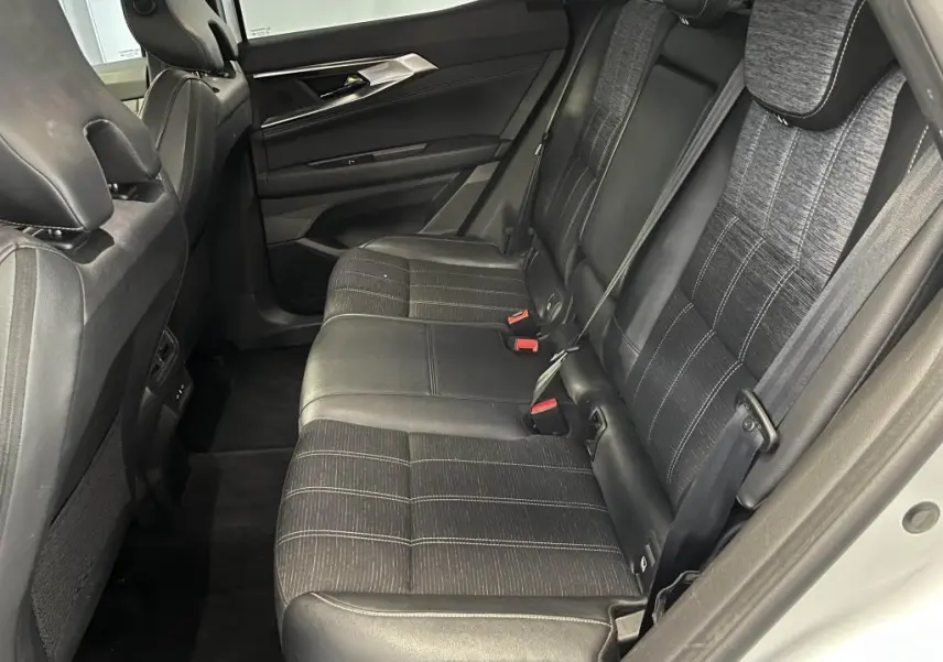 Vue côté droit de la banquette arrière en simili-cuir et tissu gris du Renault Austral blanc, avec ceintures et appuie-têtes visibles.