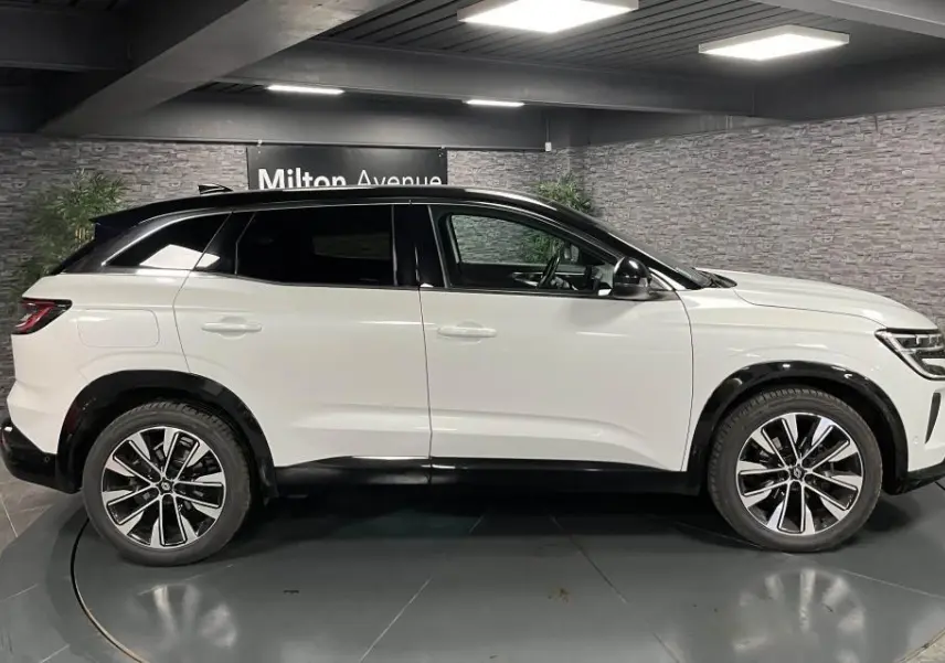 Profil droit du Renault Austral blanc Glacier avec toit noir étoilé et jantes alliage 19 pouces Komah diamantées.