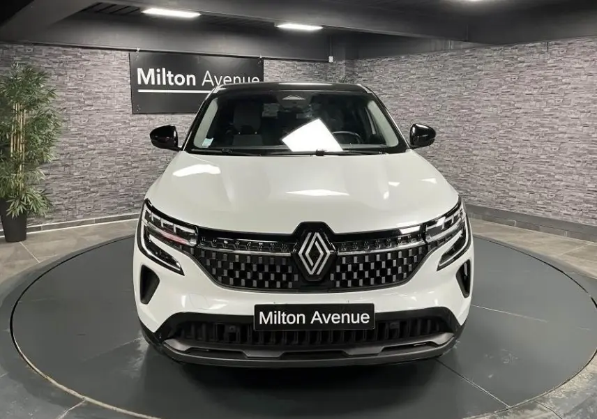 Renault Austral blanc vue de face en intérieur avec calandre damier chrome sombre et toit noir étoilé