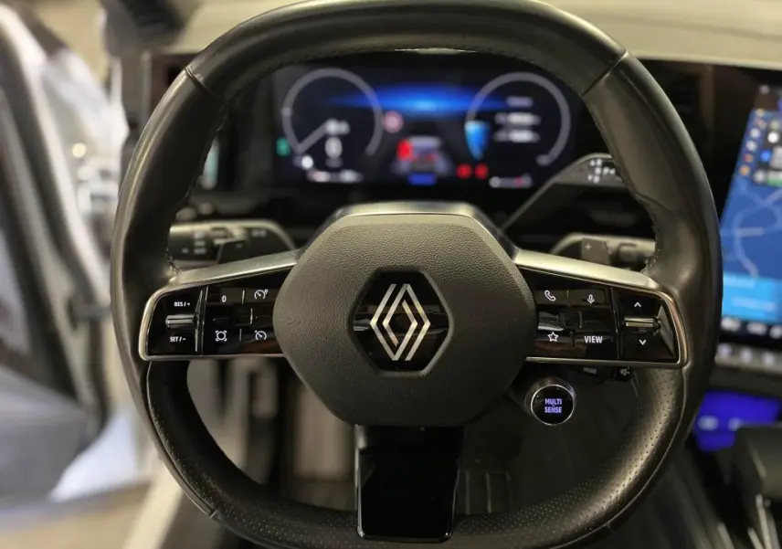 Volant cuir noir de Renault Austral 2023 avec commandes intégrées et tableau de bord numérique en arrière-plan.