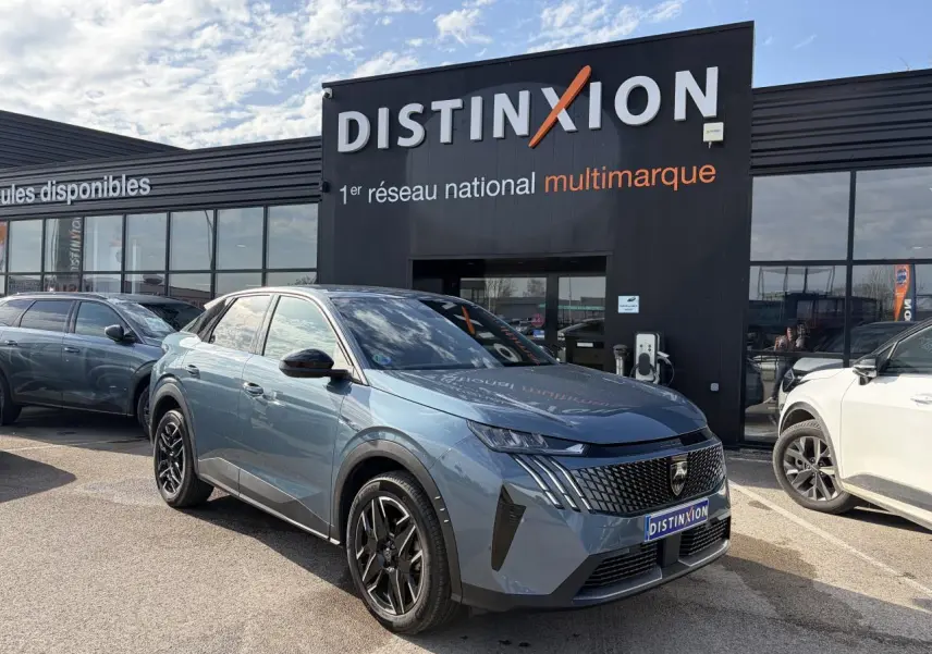 Vue 3/4 avant du Peugeot 3008 bleu Ingaro avec calandre noire et jantes alliage noires devant un showroom Distinxion.