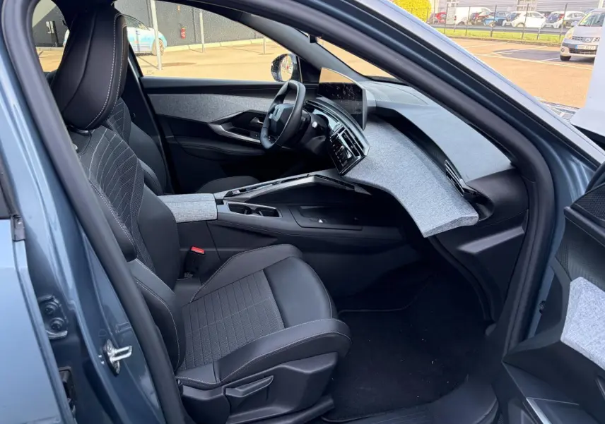Intérieur côté conducteur du Peugeot 3008 bleu Ingaro, avec tableau de bord tissu gris et écran incurvé flottant.